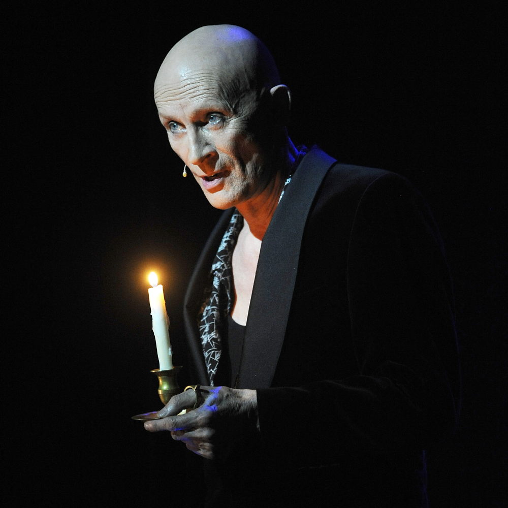 A photo of Richard O'Brien holding a lit candle