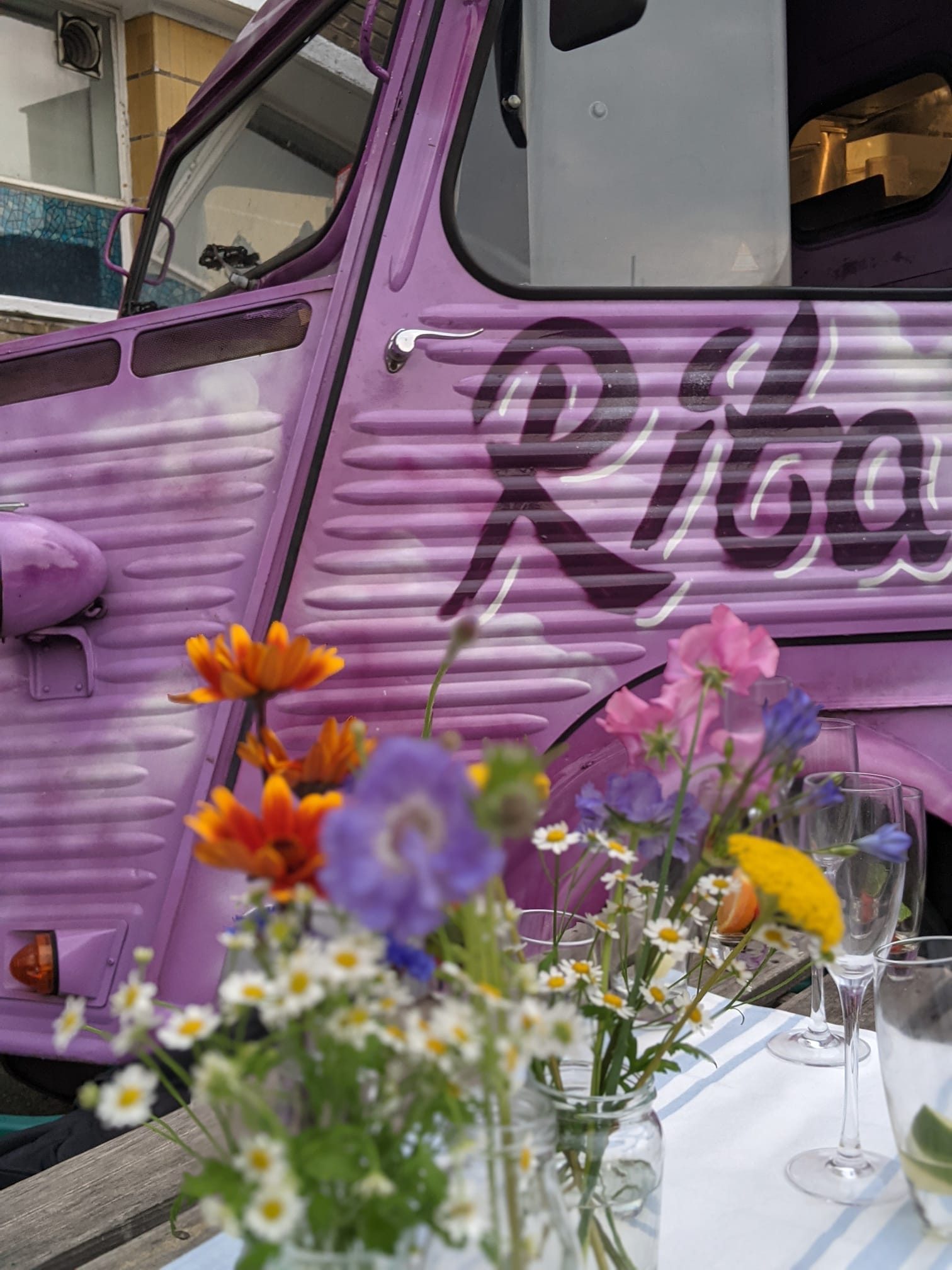 Purple van with flowers infront