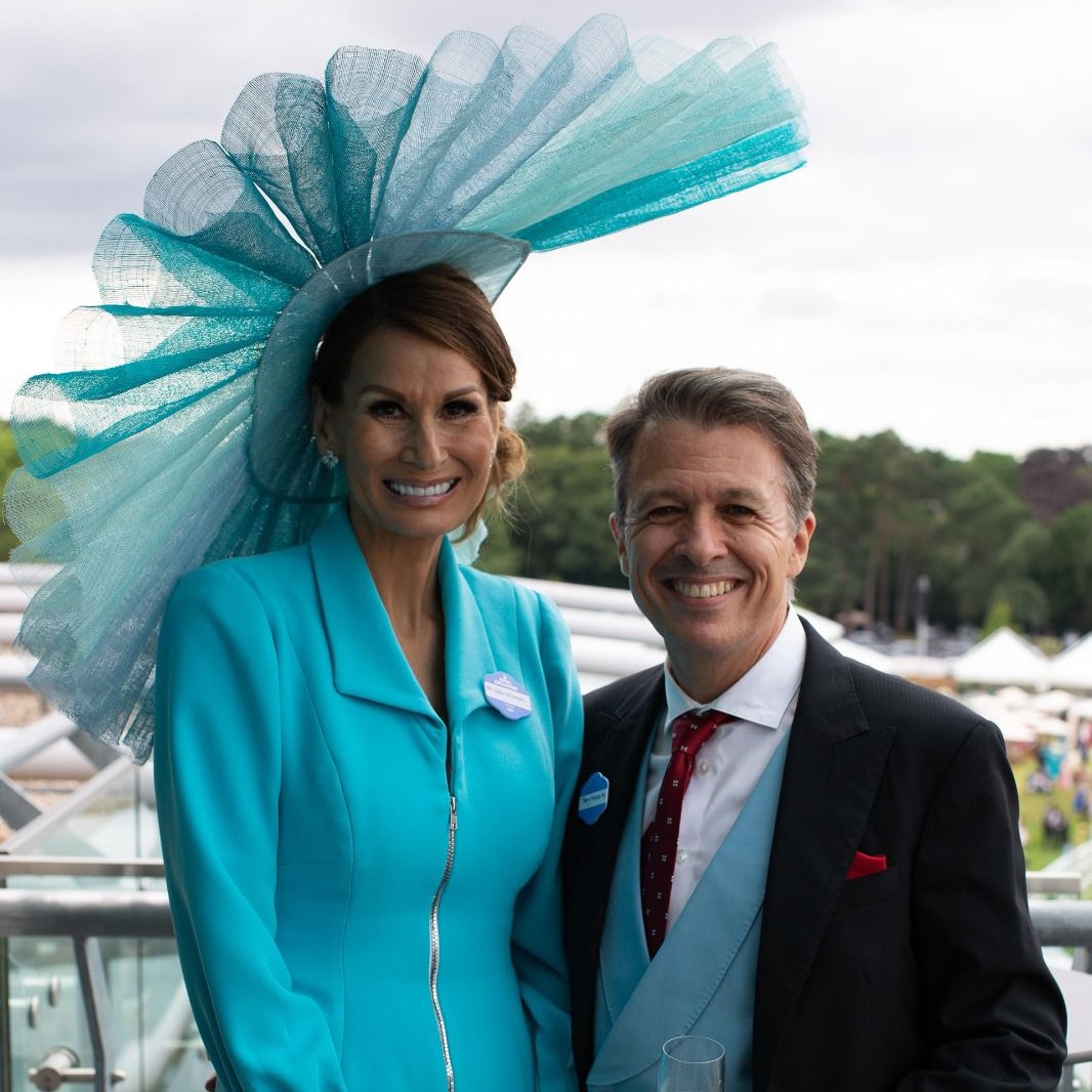 Man and woman at Royal Ascot - Lady has a large turquoise fan shaped hat